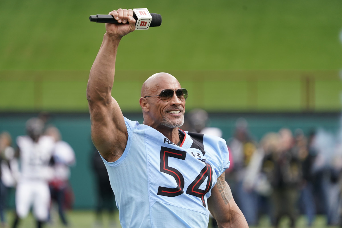 Feb 18, 2023; Arlington, TX, USA; XFL owner Dwayne Johnson talks on the field prior to game between the Vegas Vipers and the Arlington Renegades at Choctaw Stadium. Mandatory Credit: Raymond Carlin III-USA TODAY Sports  